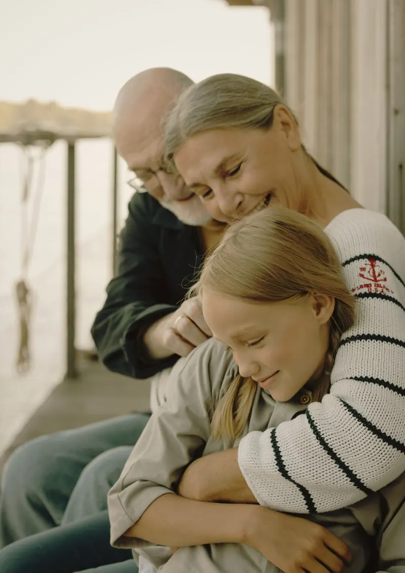 Grandparents holding their granddaughter close — three generations, one tender moment that only travel makes possible